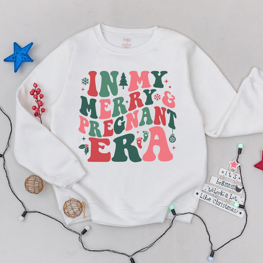 In my Merry & Pregnant Era Christmas Sweatshirt, Groovy Font Holiday Pregnancy Reveal, Xmas Gift for Mom, Red Green Pink Snowflakes