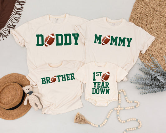First Birthday Football Tee Daddy Mommy Brother Matching Family Outfit Green Block Letters Realistic Football Accents Playful Sporty Style