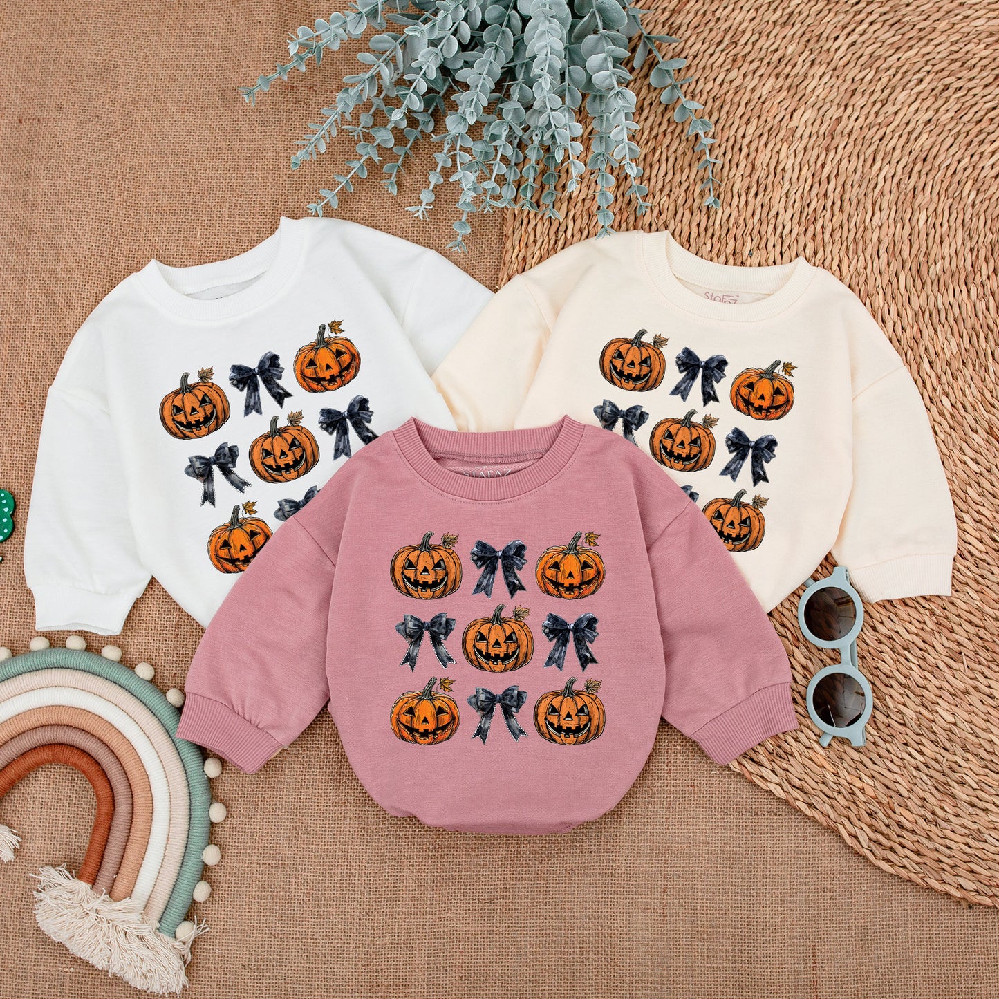 Adorable Retro Halloween Baby Romper featuring smiling jack-o'-lanterns and bows with autumn leaves a sweet first fall celebration outfit