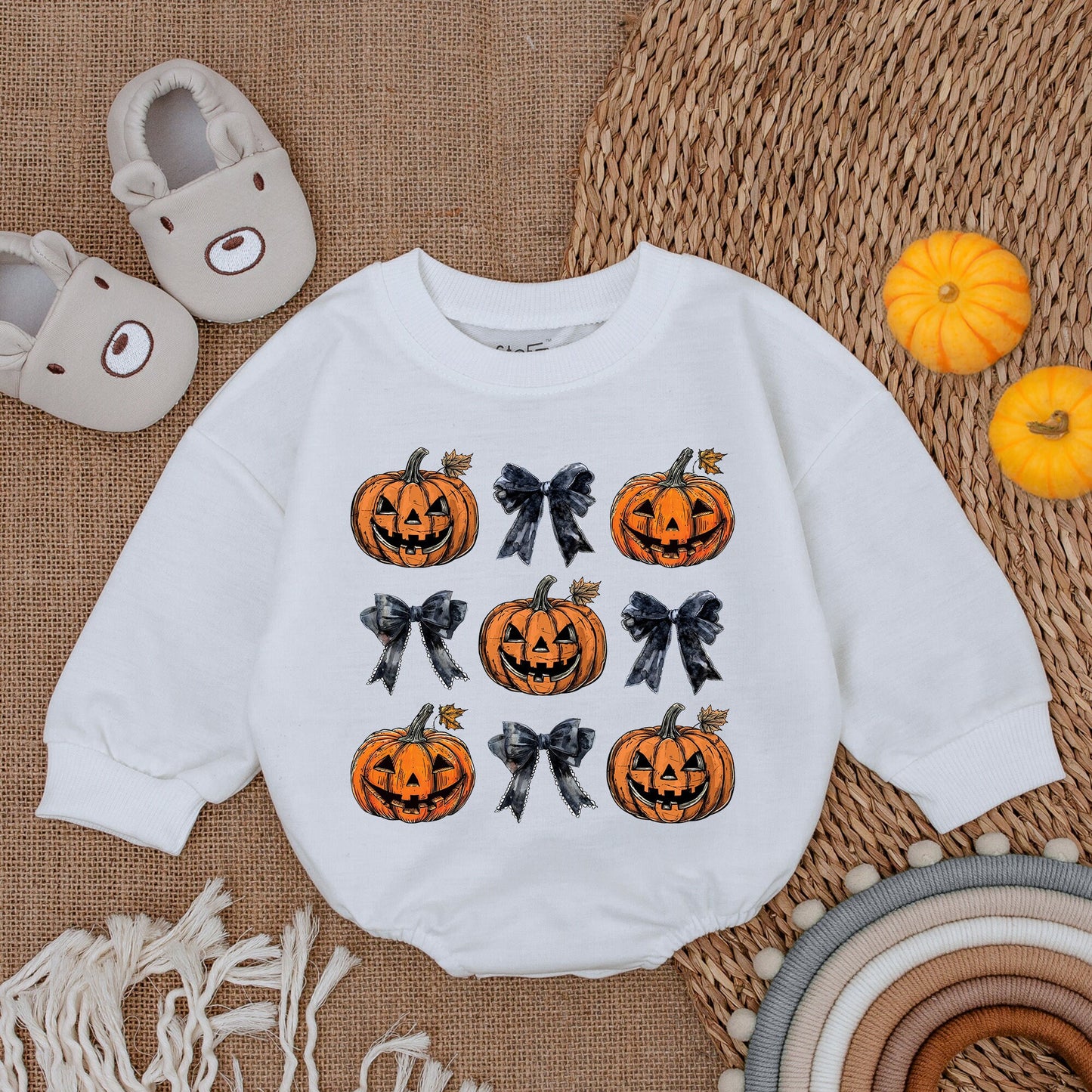 Adorable Retro Halloween Baby Romper featuring smiling jack-o'-lanterns and bows with autumn leaves a sweet first fall celebration outfit
