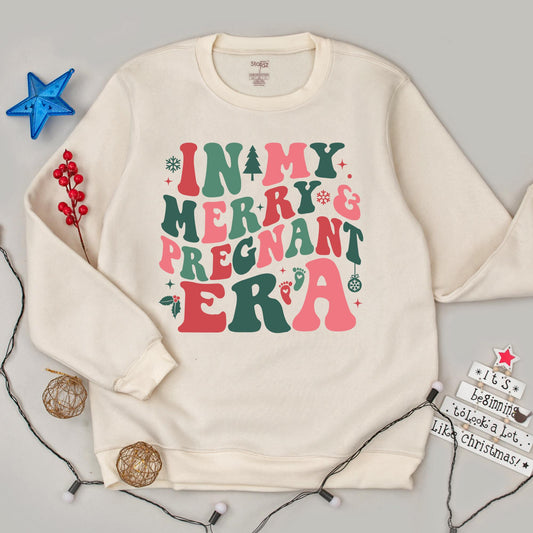 In my Merry & Pregnant Era Christmas Sweatshirt, Groovy Font Holiday Pregnancy Reveal, Xmas Gift for Mom, Red Green Pink Snowflakes