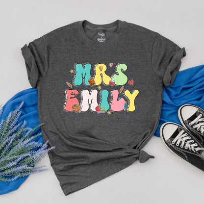 Personalized Teacher Shirt Mrs. Emily Rainbow Name Back to School Outfit, Custom Colorful Letters, Cute Heart Apple Beaker Book Pencil Graphic Gift for Women (138)