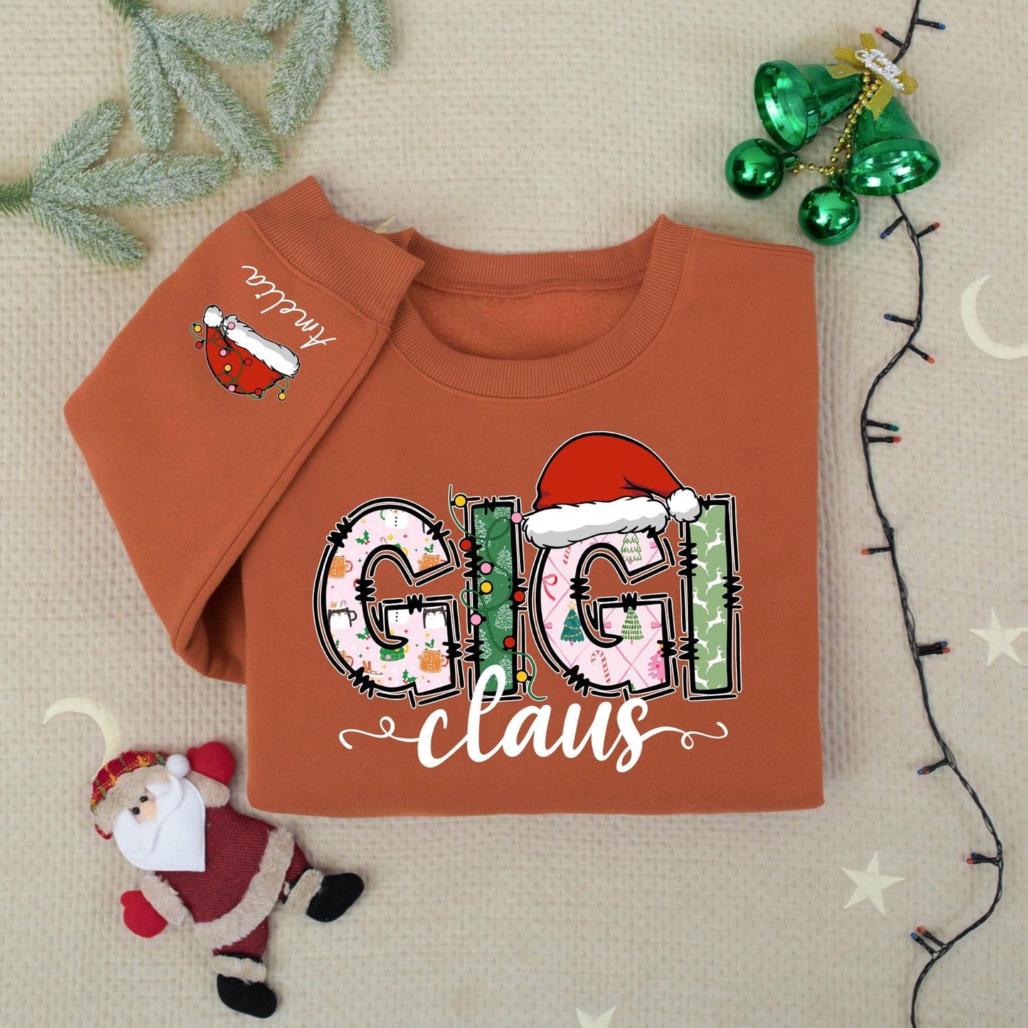 Personalized Gigi Claus Christmas Sweatshirt with Grandkids Names on Sleeve featuring festive patterned pink green white graphics comfy gift